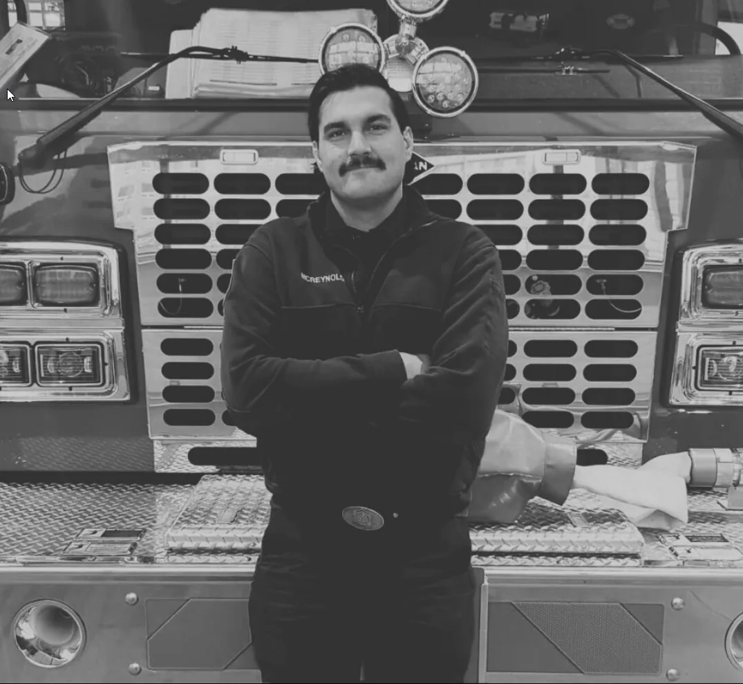 A Spruce Grove fire fighter standing in front of an engine